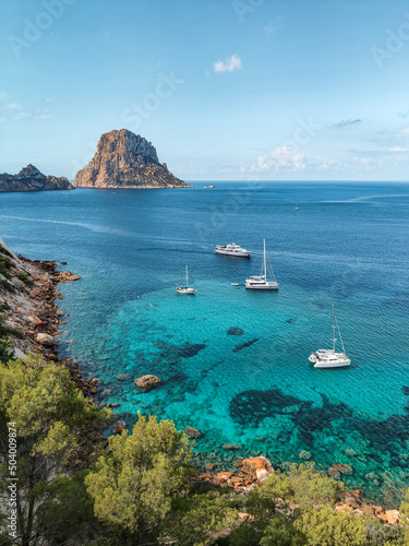 View of Es Vedra island with boats in the sea, Ibiza island, Spain photo
