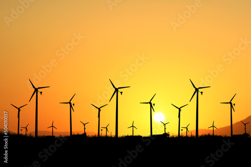 The concept of alternative energy, wind energy and clean energy. Silhouettes of wind turbines generate electricity in a field.