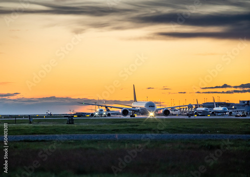 Airplanes lined up for take up at the Vancouver International Airport during sunset
