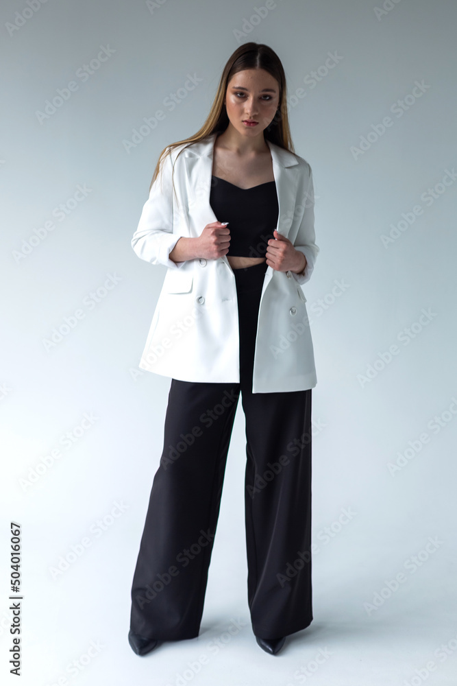 Elegant young caucasian woman in black and white suit. Businesswoman on white background Elegant young caucasian woman in black and white suit. Businesswoman on white background