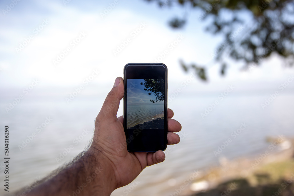 man take photo with smartphone in nature