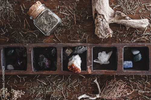 Flat lay shot of a collection of many different crystals on a messy wiccan witch's altar. Crystal magick photo