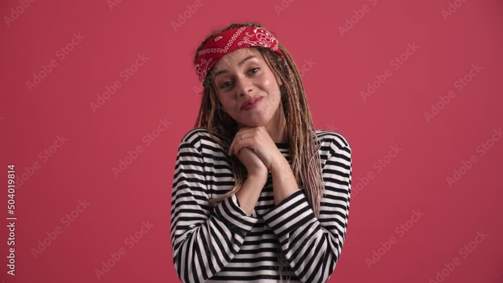 Surprised hippie woman looking at the camera in the pink studio Surprised hippie woman looking at the camera in the pink studio