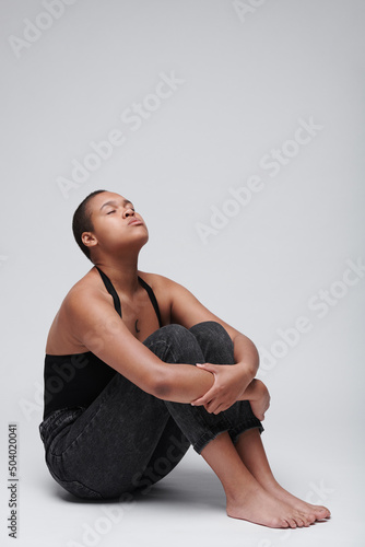 Billede på lærred Sorrowful young Afro-American woman being ill with cancer sitting with closed ey