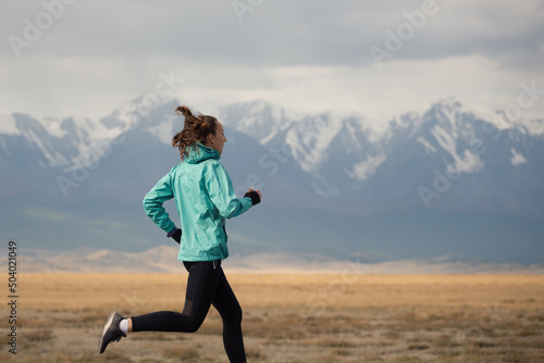 Sports girl jogging on the background of the mountains