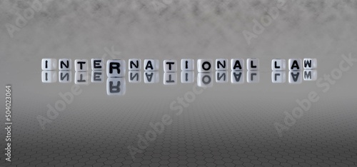 international law word or concept represented by black and white letter cubes on a grey horizon background stretching to infinity