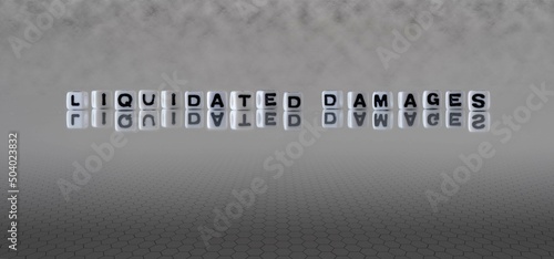 liquidated damages word or concept represented by black and white letter cubes on a grey horizon background stretching to infinity