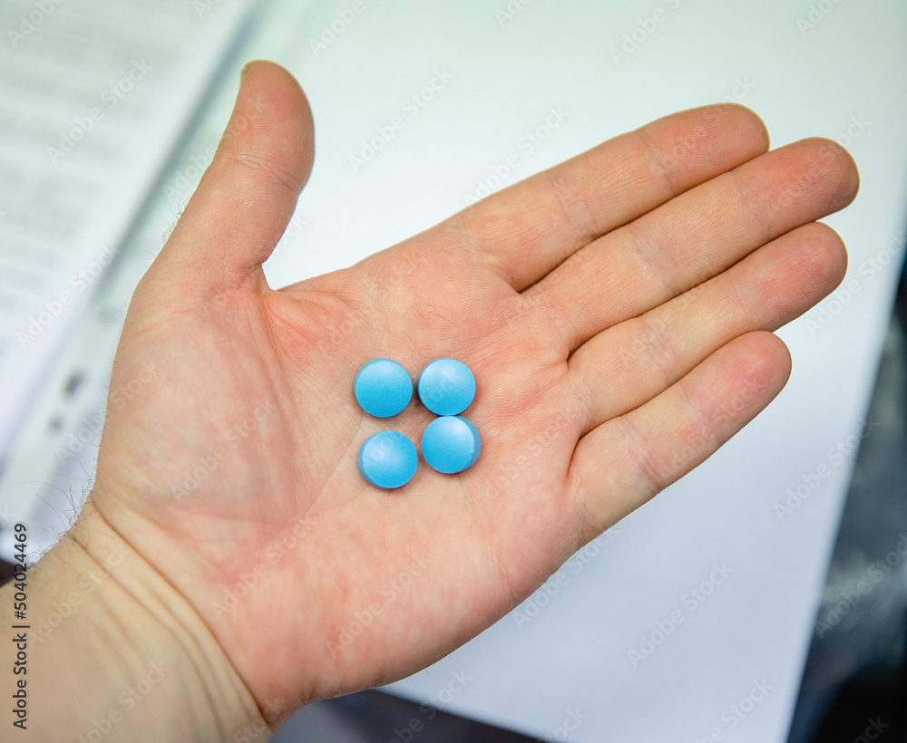 A blue pill in the man's hand. A blue pill in the man's hand.
