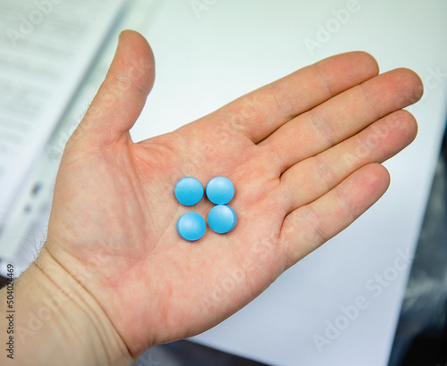 A blue pill in the man's hand.