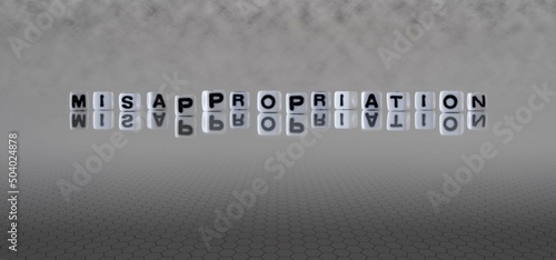misappropriation word or concept represented by black and white letter cubes on a grey horizon background stretching to infinity photo