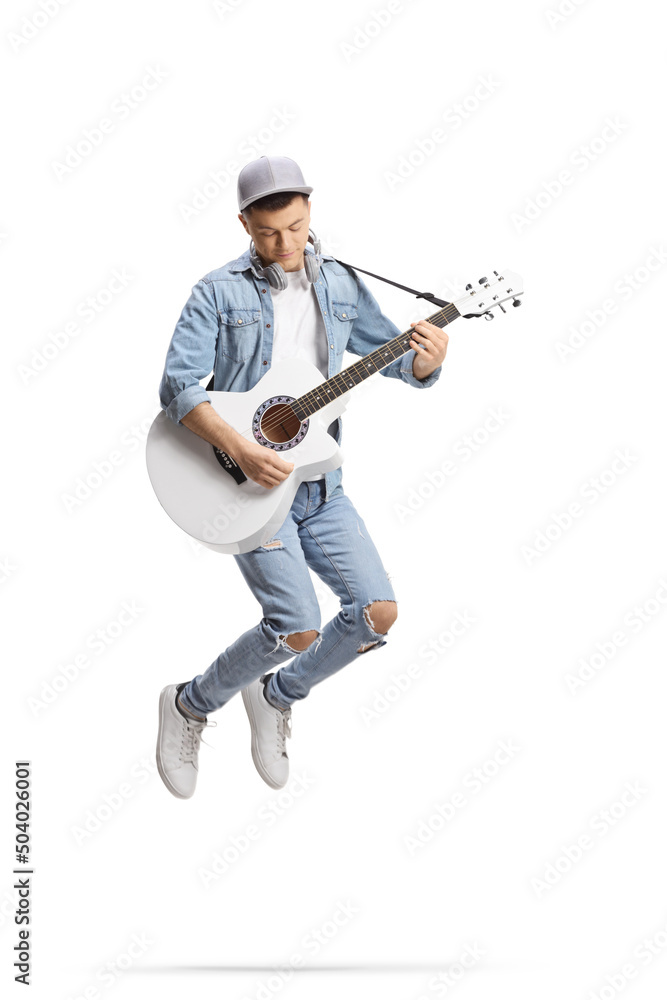 Energetic guy jumping and playing an acoustic guitar Energetic guy jumping and playing an acoustic guitar