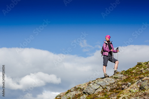 Woman Traveler with Backpack hiking in Mountains