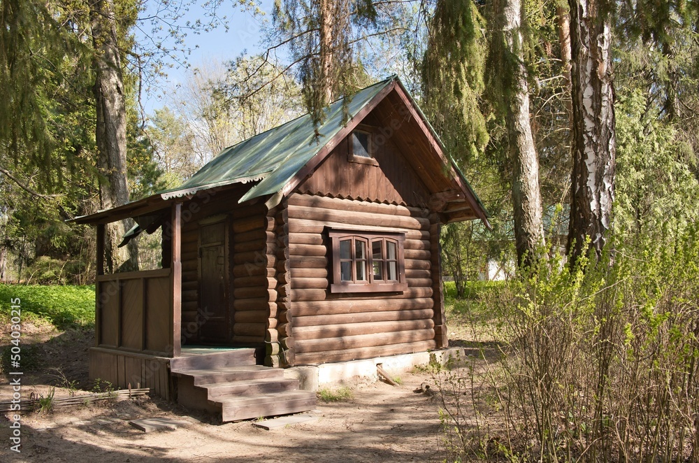 Small wooden house in forest. Forester or hunter wooden hut among the trees at summer. Small wooden house in forest. Forester or hunter wooden hut among the trees at summer.