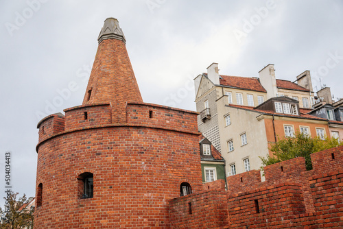 Warsaw, Poland, 13 October 2021: Barbican complex network of historic fortifications between Old and New Town, red brick fort wall with towers, major tourist attraction at sunny autumn day, city gate