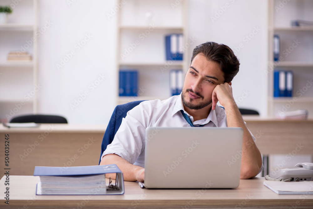 Naklejka premium Young male employee working in the office