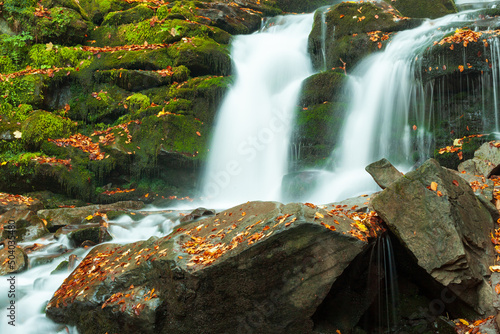 Ukpaine. Waterfall among the mossy rocks. Beautiful landscape rapids on a mountains river in autumn forest in carpathian mountains at sunset. Silver stream in National park Shypit Carpat. Pilipets. photo