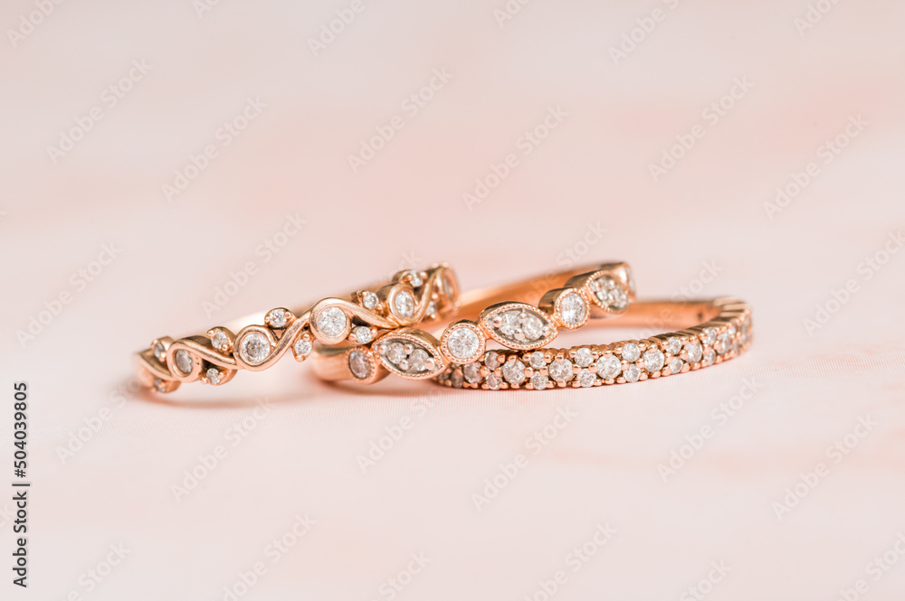 Stacked rose gold diamond ring with pink background Stacked rose gold diamond ring with pink background