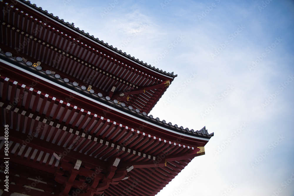 The colorful roof structure of Senso Ji temple in Tokyo, Japan in front of a bright blue sky creates a powerful contrast. Abstract background. 