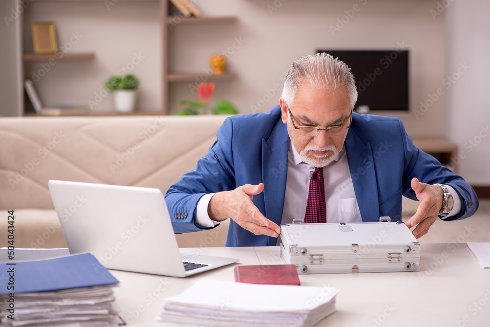 Old male employee in remuneration concept at home Old male employee in remuneration concept at home