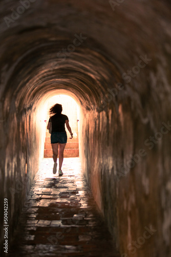 photo of a woman running in a tunnel 