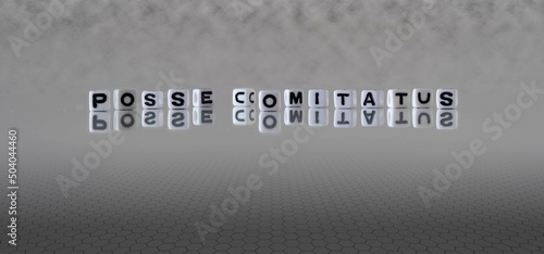 posse comitatus word or concept represented by black and white letter cubes on a grey horizon background stretching to infinity