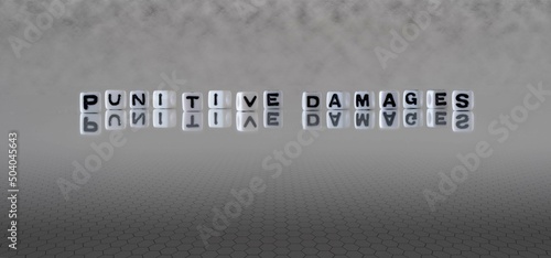 punitive damages word or concept represented by black and white letter cubes on a grey horizon background stretching to infinity