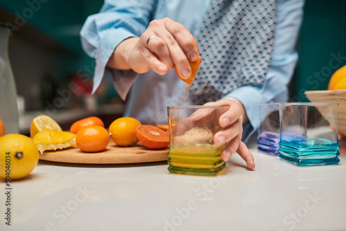 A close up photo of a woman's hand cutting and preparing fruits to make a healthy smoothie. The concept of a healthy lifestyle