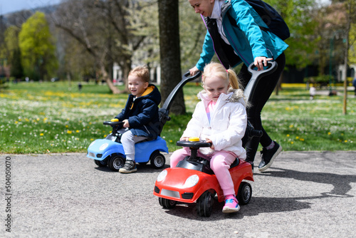 Mother Rolls Her Kids on a Toy Car