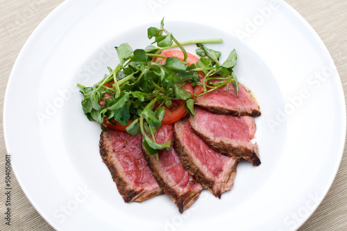 Slices of beef with tomatos and salad