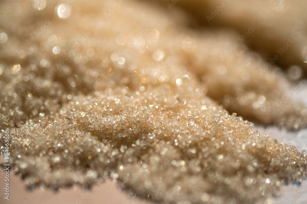 The texture of a yellow shining scrub on a beige background. The texture of a yellow shining scrub on a beige background.