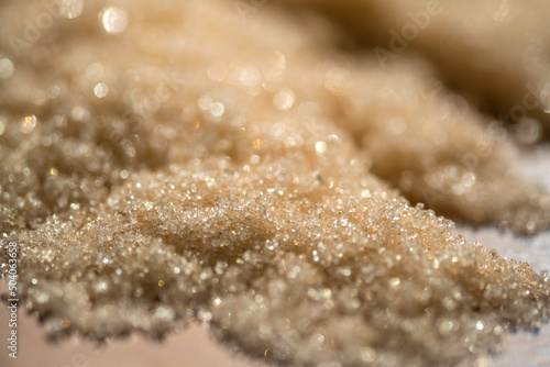 The texture of a yellow shining scrub on a beige background.