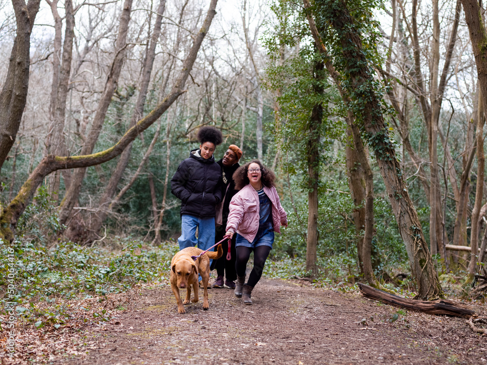 Mother with two daughters and dog in forest Mother with two daughters and dog in forest