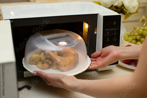 Fotografie A plate of food in the microwave covered with a lid
