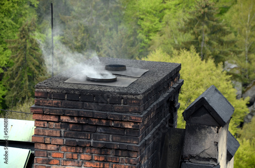 a dirty chimney in which coal is heated. soot is everywhere on the brick masonry. in the spring in the woods at the cottage. Victorian style. ecological way of heating houses and flats photo