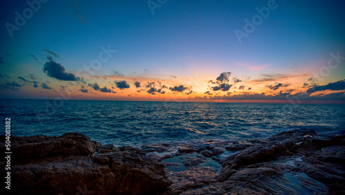 Blurred nature background of the morning sun by the sea  a beautiful golden light  among the trees  rocks and local fishing boats  the beauty of nature during the day.