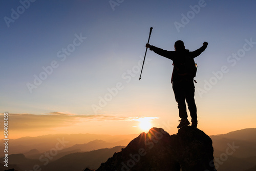 Silhouette woman backpacking travel atop a high rock, sports and active life concept, success.