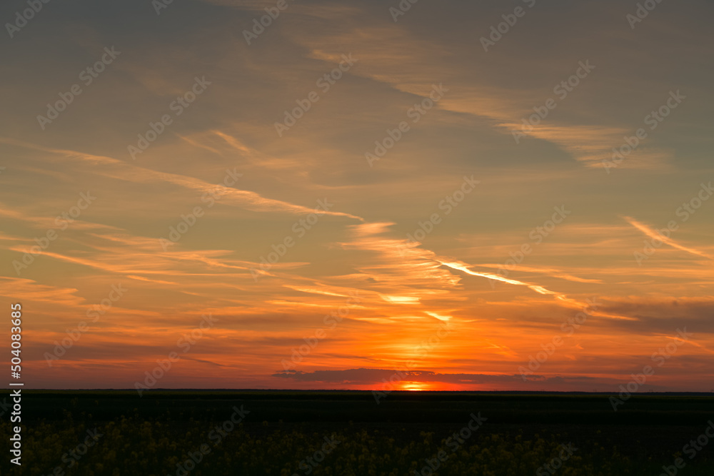 Amazing orange summer sunset with spectacular clouds on sky. Great landscape good to be used as background.