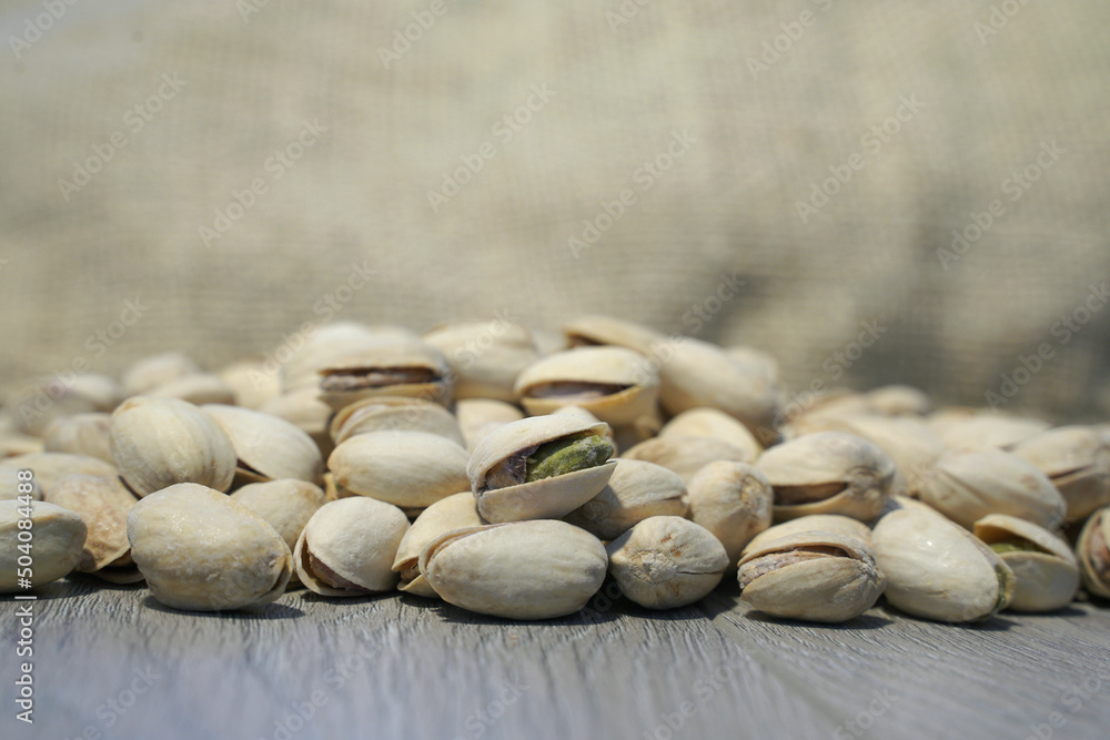 pistachio nuts on wooden background. selective focus, blurred background. pistachio nuts on wooden background. selective focus, blurred background.