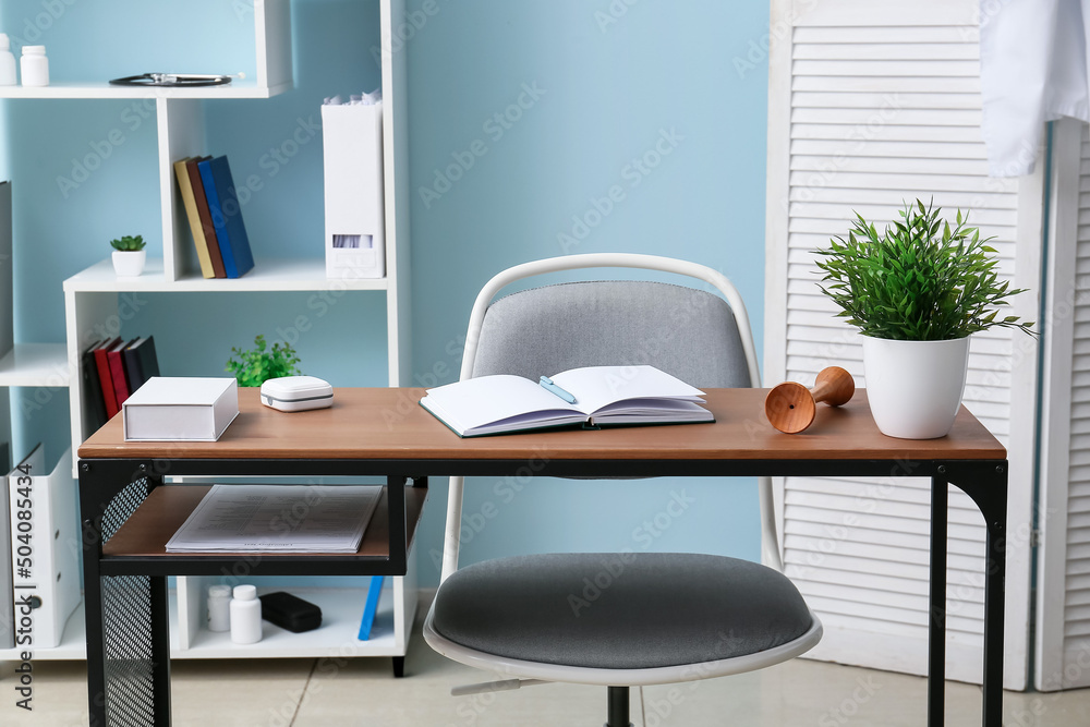 Doctor's workplace with notebook in interior of modern medical office Doctor's workplace with notebook in interior of modern medical office