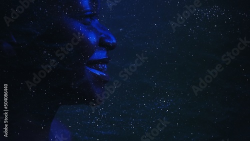 Galaxy inspiration. Astrology science. Neon blue side view silhouette of smiling woman face on dark cosmic dust star night sky empty space background.