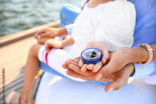 Young family with compass resting on yacht