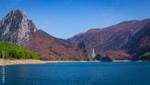 View of the green water of the Oymapinar Dam with green trees on the shore