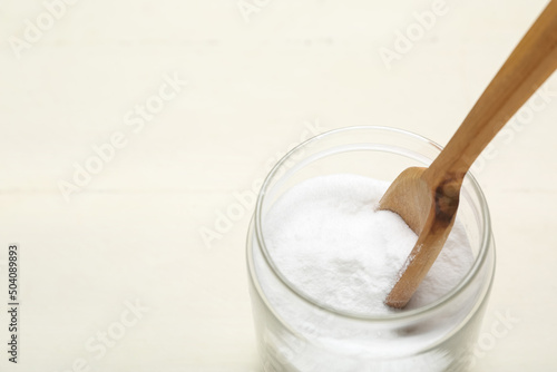 Jar with baking soda on white wooden background, closeup