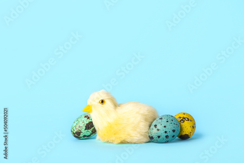 Cute yellow chicken and Easter eggs on blue background