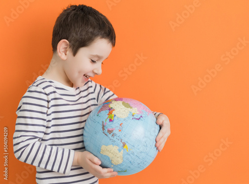 Boy with globe on orange background