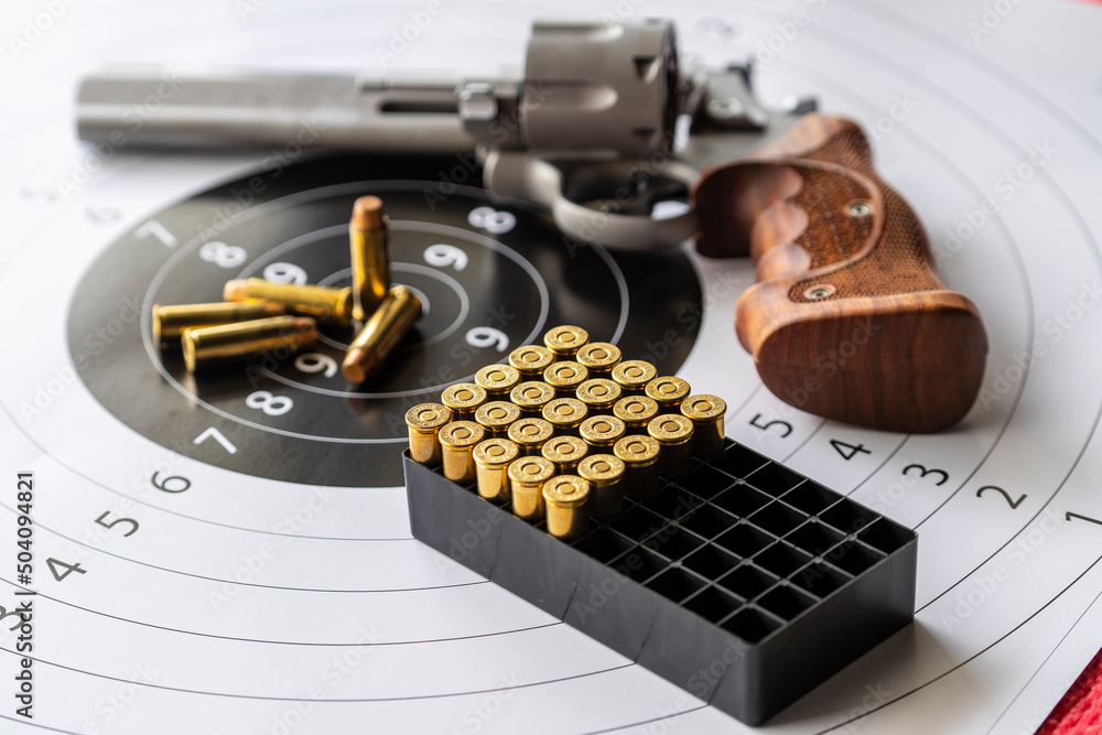 Revolver gun and bullets on background of the target Revolver gun and bullets on background of the target
