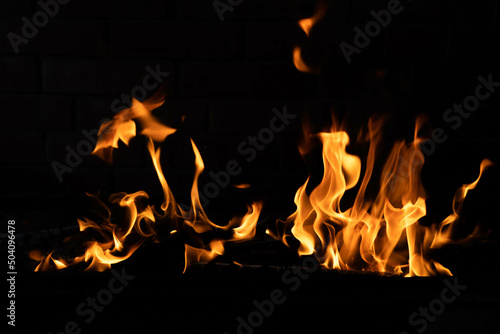 The texture of the fire is close, red and yellow, thermal energy at the fuel supply point at night, lights on a black background.