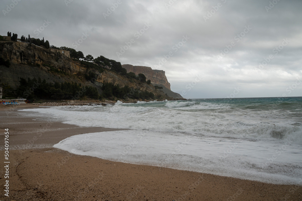Stormy sea, high waves on yellow sandy beach in Cassis, Provence, France