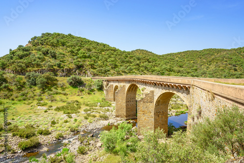 An ancient arched bridge spans over Salor river in Extremadura, Spain
