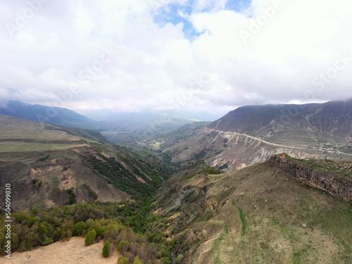 panoramic view of the Caucasus Mountains gorges ancient fortresses and curved mountain roads on a spring day taken from a drone